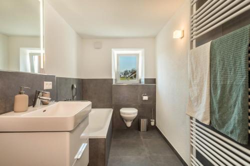 a white bathroom with a sink and a toilet at Ferienwohnung Pusteblume in Neukirch