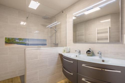 a bathroom with a sink and a mirror at Maison de vacances Chez André in Meslan