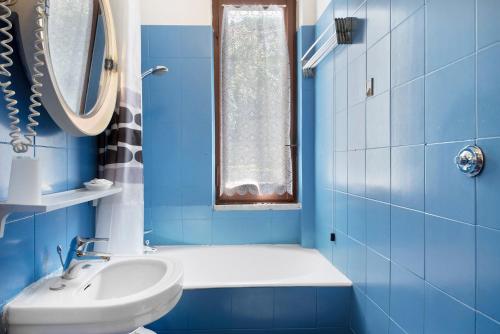 a blue bathroom with a sink and a toilet at Appartamento Monolocale Moneglia 24 in Moneglia