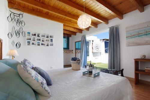 a bedroom with a bed and a large window at Vista Tostón in El Cotillo