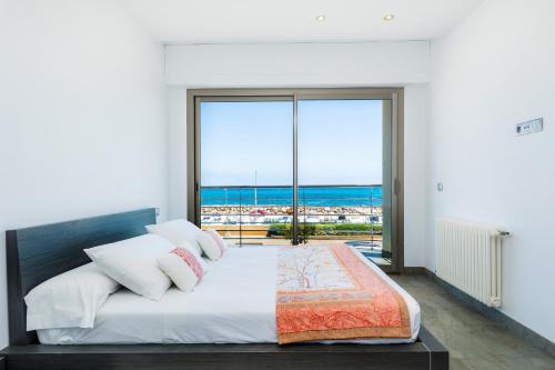 a bedroom with a bed with a view of the ocean at Bohemi in Son Serra de Marina