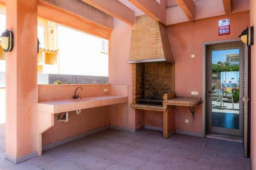 an outdoor kitchen with a fireplace in a building at Bohemi in Son Serra de Marina