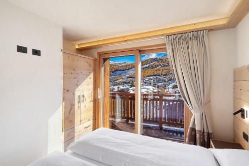 a bedroom with a bed and a large window at Livigno Wooden House in Livigno