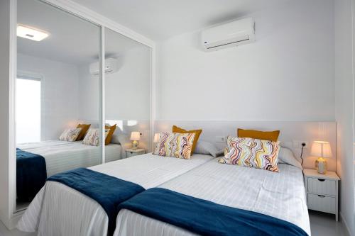 a bedroom with two beds and a mirror at Kay 4 in La Santa
