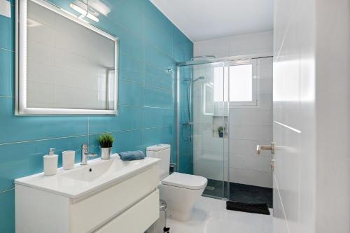 a bathroom with a sink and a toilet and a mirror at Kay 4 in La Santa