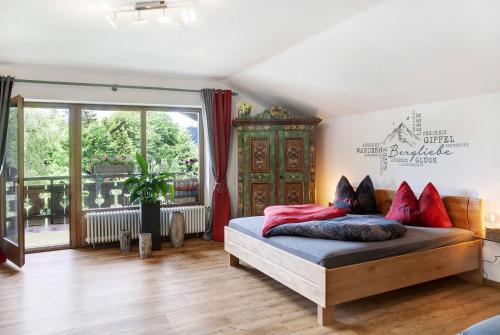 a bedroom with a bed with red pillows on it at Aschaubichl - Wohnung Anemone in Grainau