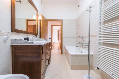 a bathroom with a sink and a tub and a toilet at Appartamento Ania vista castello in Tenno