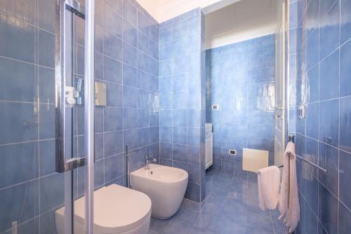 a blue tiled bathroom with a toilet and a sink at Villa Chiara in Lipari