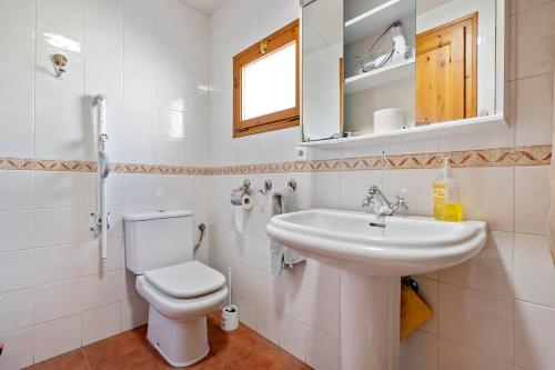 a bathroom with a toilet and a sink and a mirror at Ca Cedó in Serra de Almós
