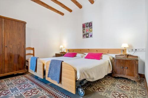 a bedroom with a large bed with pink pillows at Ca Cedó in Serra de Almós