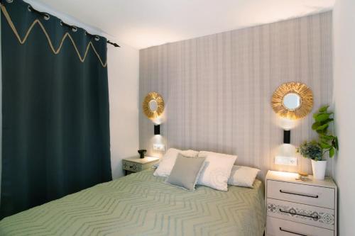 a bedroom with a bed with two mirrors on the wall at Dreaming Penthouse Mogan in Mogán