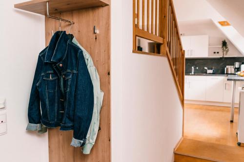 a denim jacket hanging on a wall next to a staircase at Ferienwohnung Alte Schneiderei in Heideck