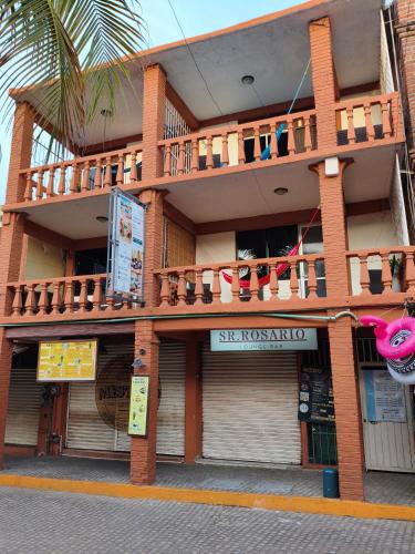 a building with a balcony on top of it at Hotel Casa Lucina in Zihuatanejo
