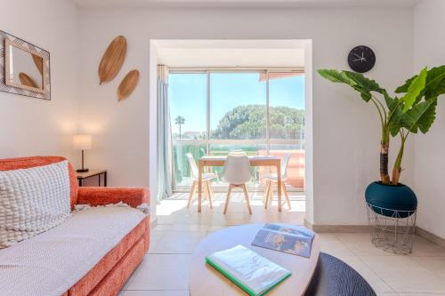 a living room with a couch and a table at Azur et Lavande proche plage in Fréjus