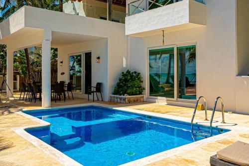 a swimming pool in front of a house at Oceanfront home with beach access pool balconies & waterfront hammocks - Villa Sol in Tulum