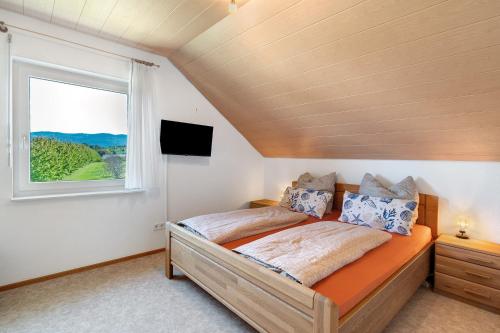 a bedroom with a bed and a window at Haus Langer in Oberkirch
