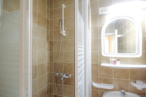 a bathroom with a shower and a toilet and a mirror at Guesthouse Junior in Kopaonik