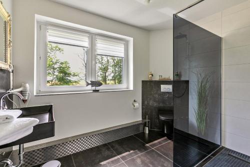 a bathroom with a shower and a sink and a window at Föhr in Galmsbüll