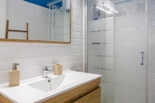 a white bathroom with a sink and a mirror at Cozy Apartment Blanes in Blanes