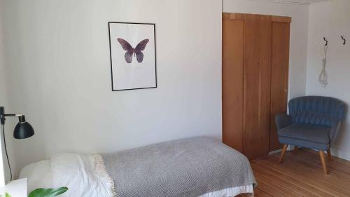 a bedroom with a bed and a butterfly picture on the wall at Hyllemose Guesthouse in Lille Skensved