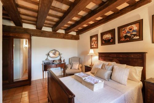 a bedroom with a bed and a desk and a chair at Casa Farigola in El Bruc