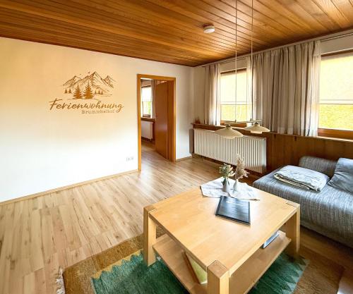 a living room with a table and a couch at Brumichelhof in Bad Peterstal-Griesbach