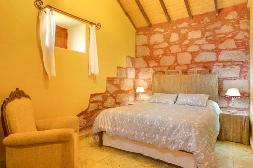 a bedroom with a bed and a chair and a mirror at Casa Rural Serafín in Tejeda