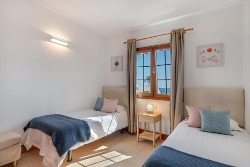 a bedroom with two beds and a window at Villa Turqué in Arrieta