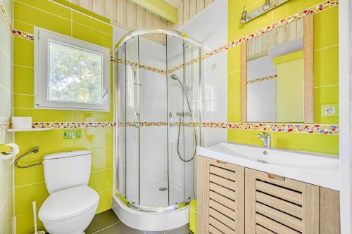 a bathroom with a shower and a toilet and a sink at Joli Petit Chalet La Cote d'Argent in Le Porge