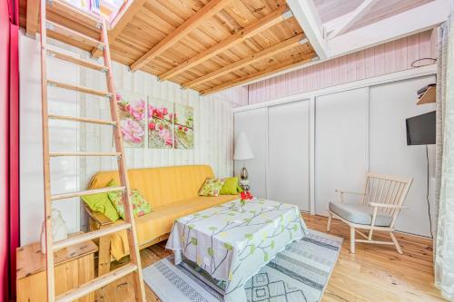 a living room with a bunk bed and a ladder at Joli Petit Chalet La Cote d'Argent in Le Porge