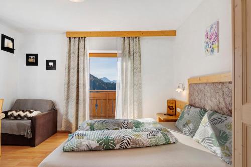 ein Schlafzimmer mit einem Bett und einem großen Fenster in der Unterkunft Tratterhof in Avelengo