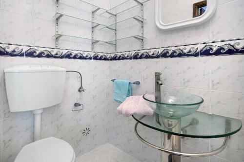 a bathroom with a glass sink and a toilet at A O - Apartamento Aires in Peniche
