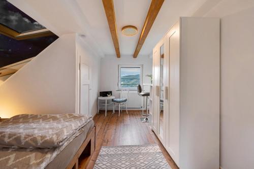 a bedroom with a bed and a desk in a room at Fewo im Rosenberg mit Dachterasse in Lahnstein