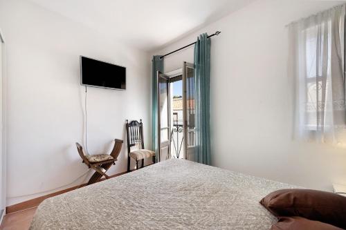 a bedroom with a bed and a tv on the wall at Mdc - Muralhas da Cidade in Lagos
