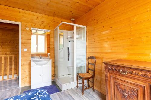a bathroom with a shower and a sink and a chair at Gite Du Dombief in La Chaux-du-Dombief