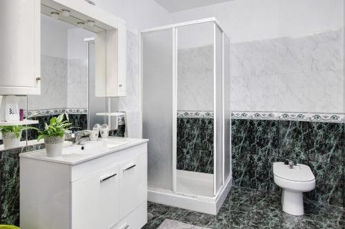 a white bathroom with a shower and a toilet at Apartamento Bali com Piscina in Apúlia