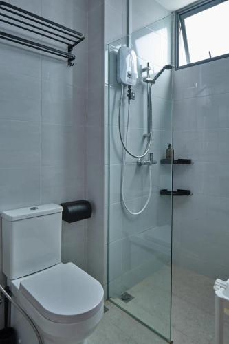 a bathroom with a glass shower with a toilet at House Rong in Singapore