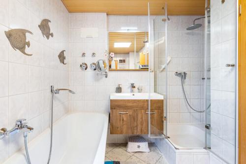 a bathroom with a tub and a sink and a shower at Gohrischblick in Kurort Gohrisch