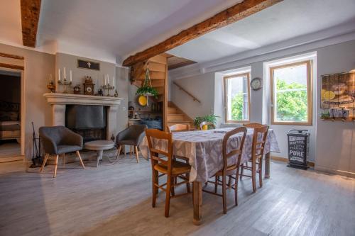 a dining room with a table and chairs at Appart Authentique et Confortable in Valderoure