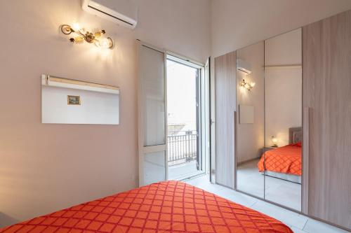 a bedroom with a red bed and a large window at Seacastle Sicily in Castellammare del Golfo