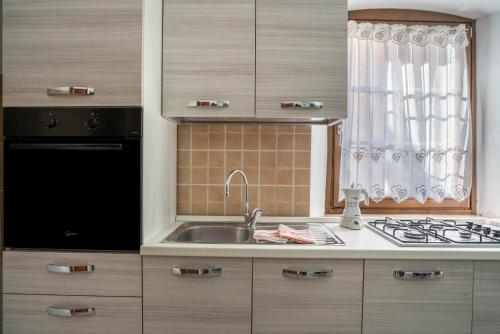 a kitchen with a sink and a stove at La vecia casa apartament in Denno