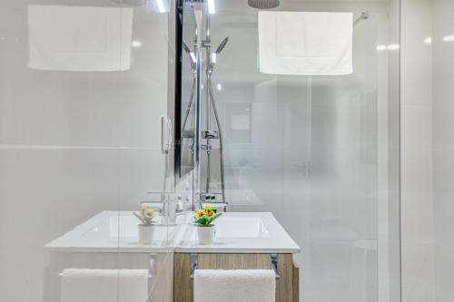 a white bathroom with a sink and a shower at Murtra Apartment in Roses