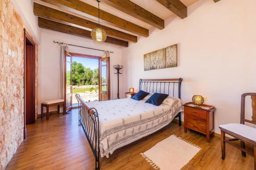 a bedroom with a bed and a wooden floor at Finca Can Simonet in Santanyi