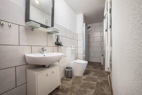 a white bathroom with a sink and a toilet at Ferienwohnung Knopf in Hardegsen