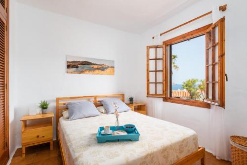 a bedroom with a bed with a tray on it at Vistafaro in Es Mercadal