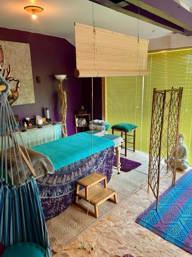 a bedroom with a large bed and a room with purple at Gite Charmant Forme et Bien-etre in Masseret
