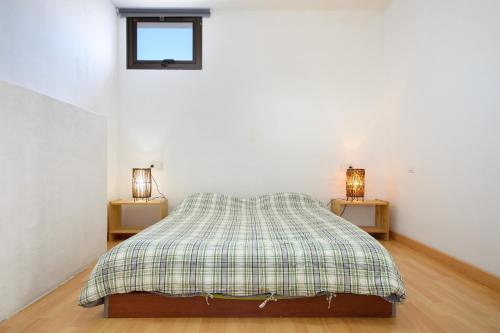a bedroom with a bed with a plaid blanket at Famara Beach Apt in Famara