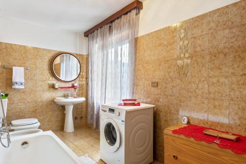 a bathroom with a washing machine and a sink at Alloggio Chez Favre in Blavy