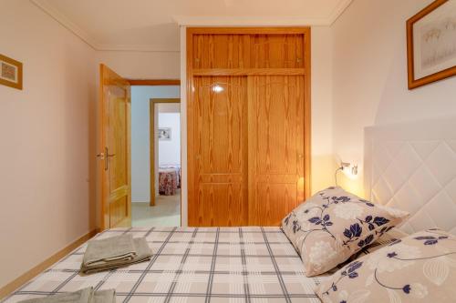 a bedroom with a bed and a wooden door at Bungalow 145 in Santa Pola