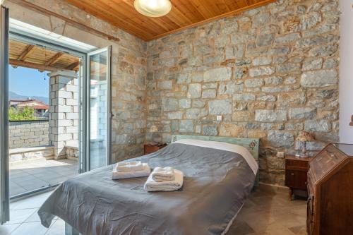 a bedroom with a bed and a stone wall at Angelina’s Stone Village House in Valíra